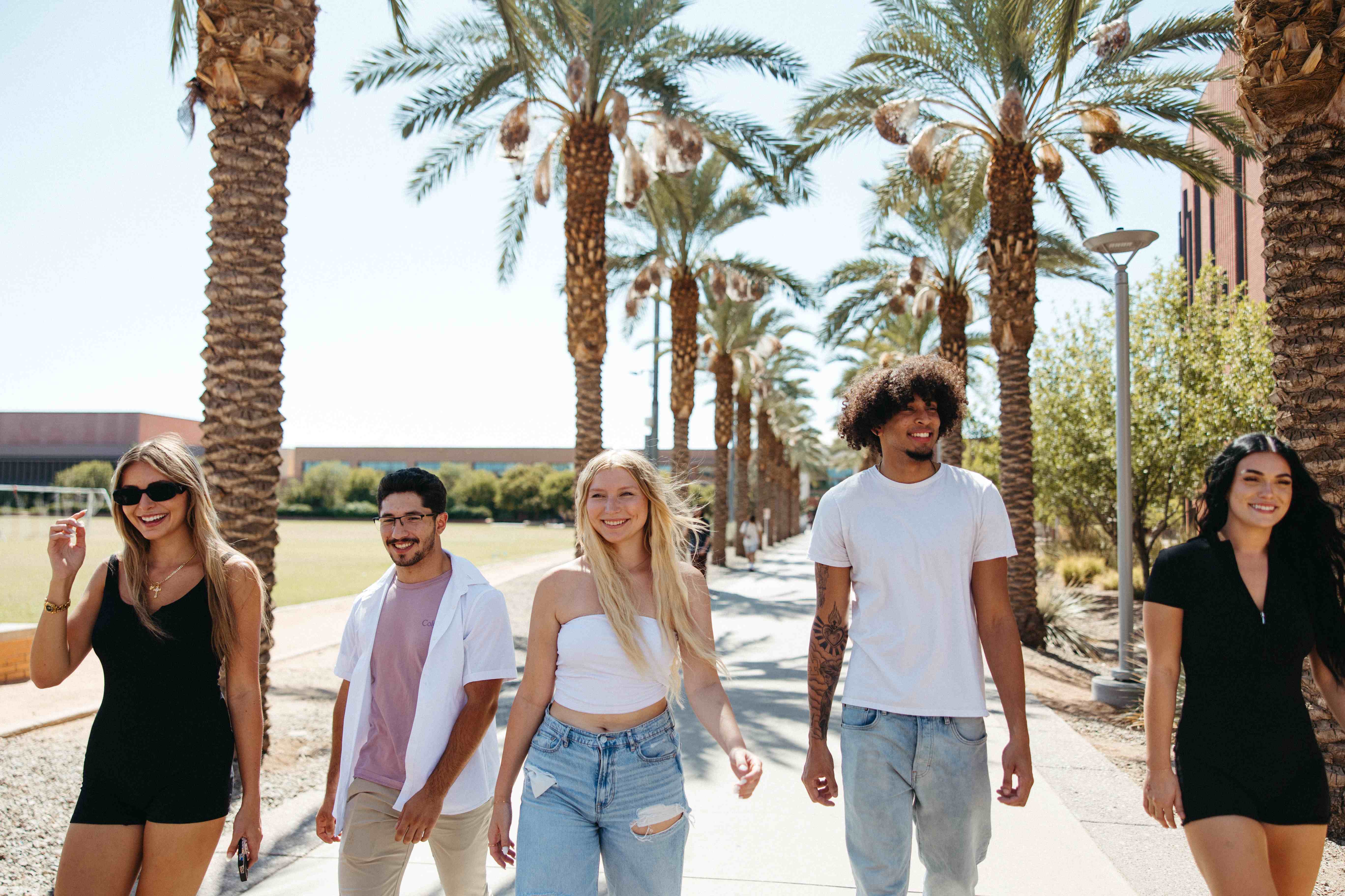 Students and friends walking across Arizona State University's campus. Specifically down the famous palm walk.