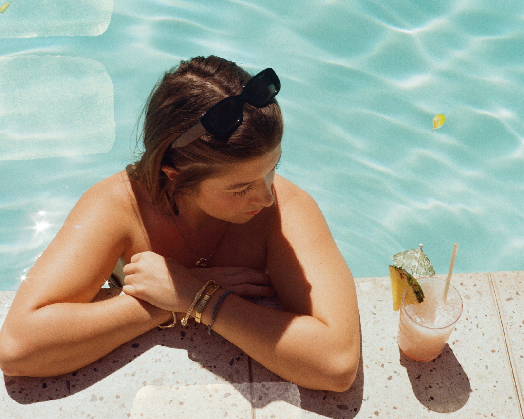 Girl with a drink by the pool