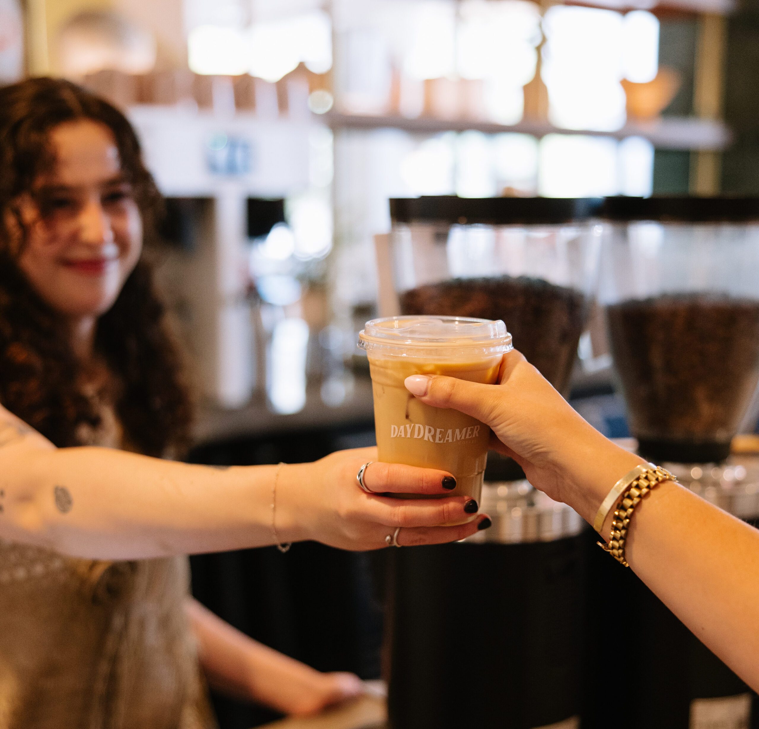 Rambler Tempe Barista at Daydreamer handing a student an Iced latte