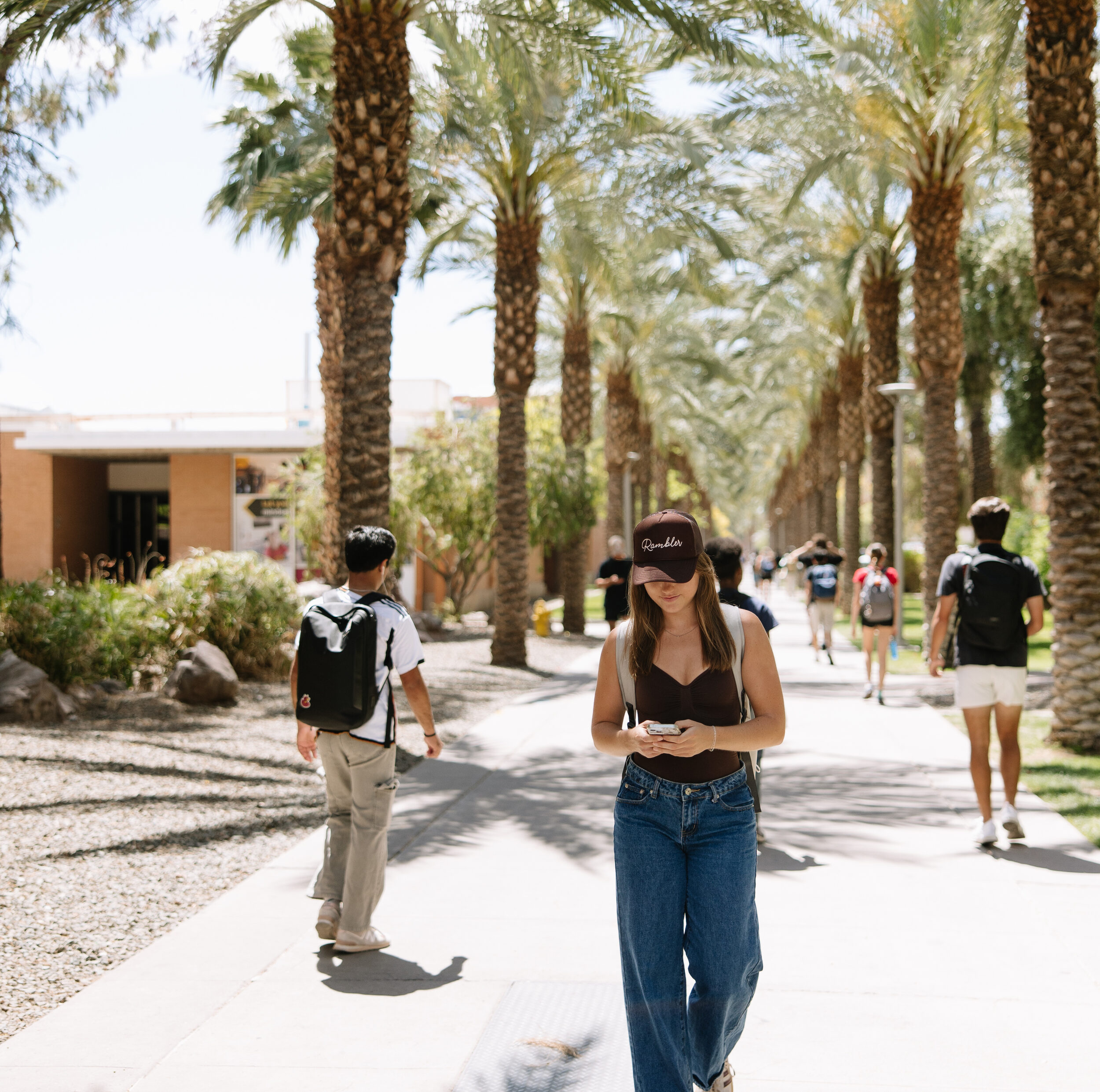 Rambler Tempe ASU student walking through campus texting on phone