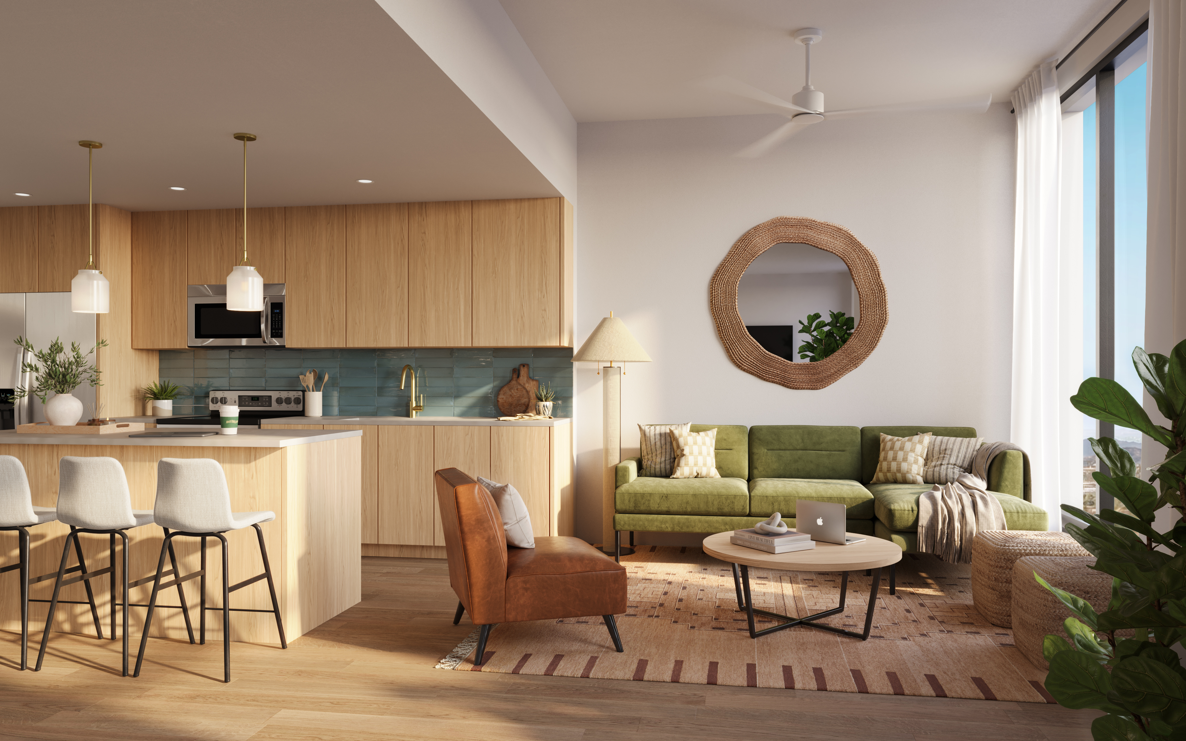 Modern open-concept living room and kitchen with wood accents, a green sofa, brown armchair, round mirror, indoor plants, and barstools at a light wood island. Sunlight streams through large windows.