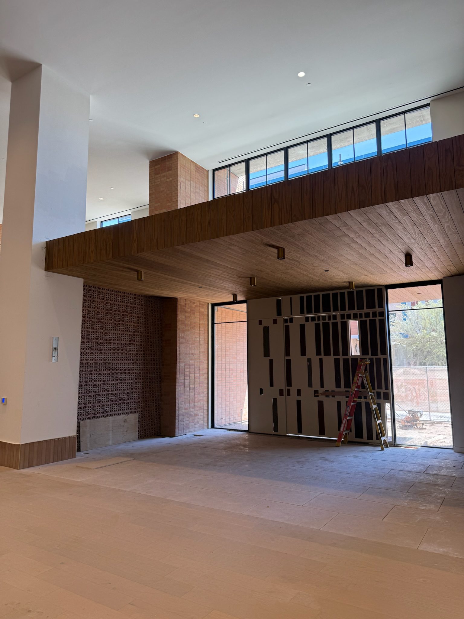 Wood ceiling detailing between floors 1 and 2 adding warmth to the building's main thoroughfares.