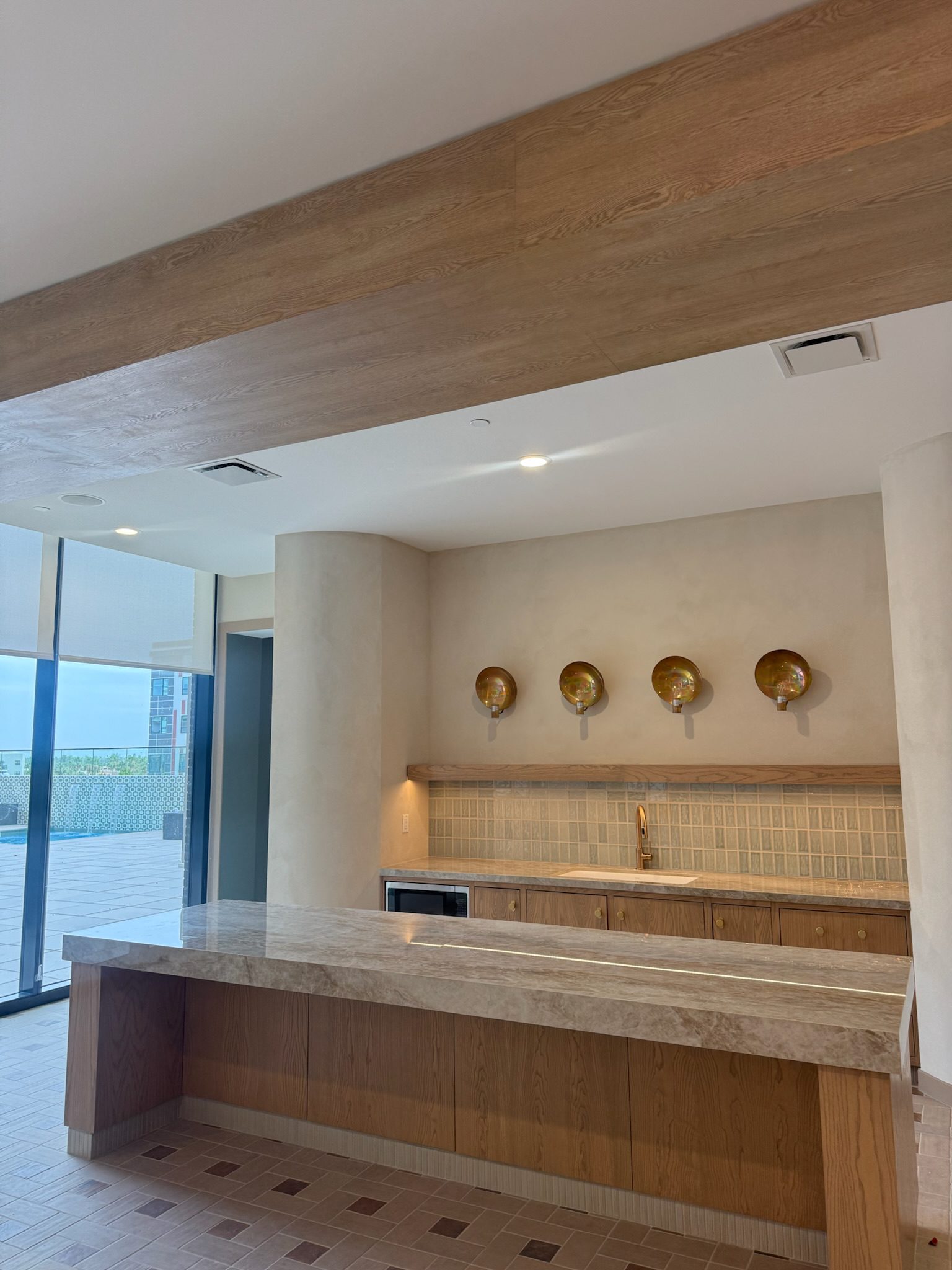 The clubroom kitchenette complete with warm brass fixtures and clean finishes.