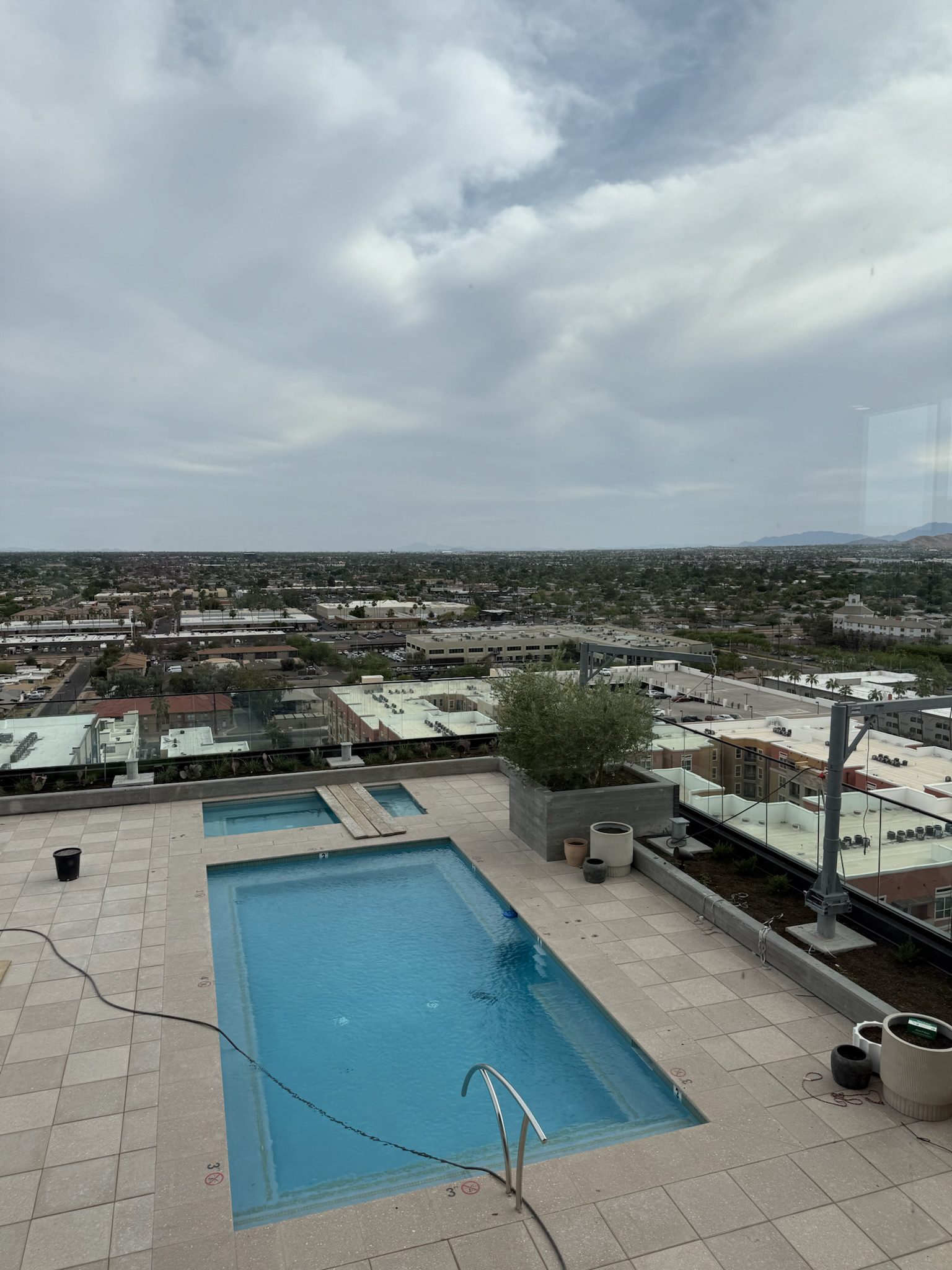 The 14th floor rooftop pool filled with water, turf and tiling complete and glass guardrails installed.